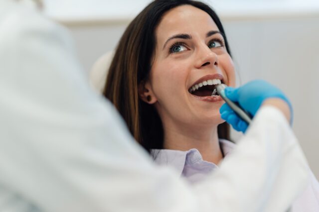 Dentist using intraoral scanner for dental checkup on patient