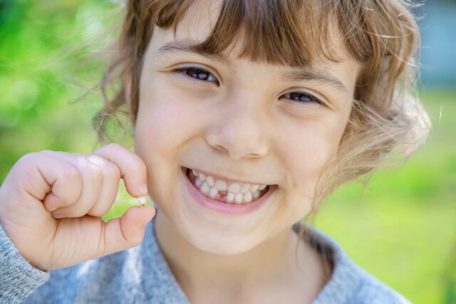 The kid had a baby tooth. Selective focus.